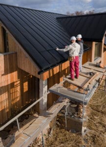 Roofers working together with helmets